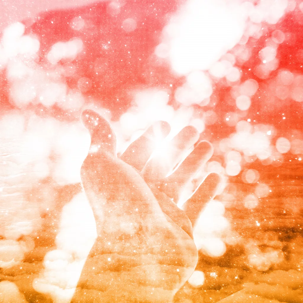 A hand reaches towards a soft, glowing light with sparkles surrounding it, evoking a sense of wonder and tranquility.