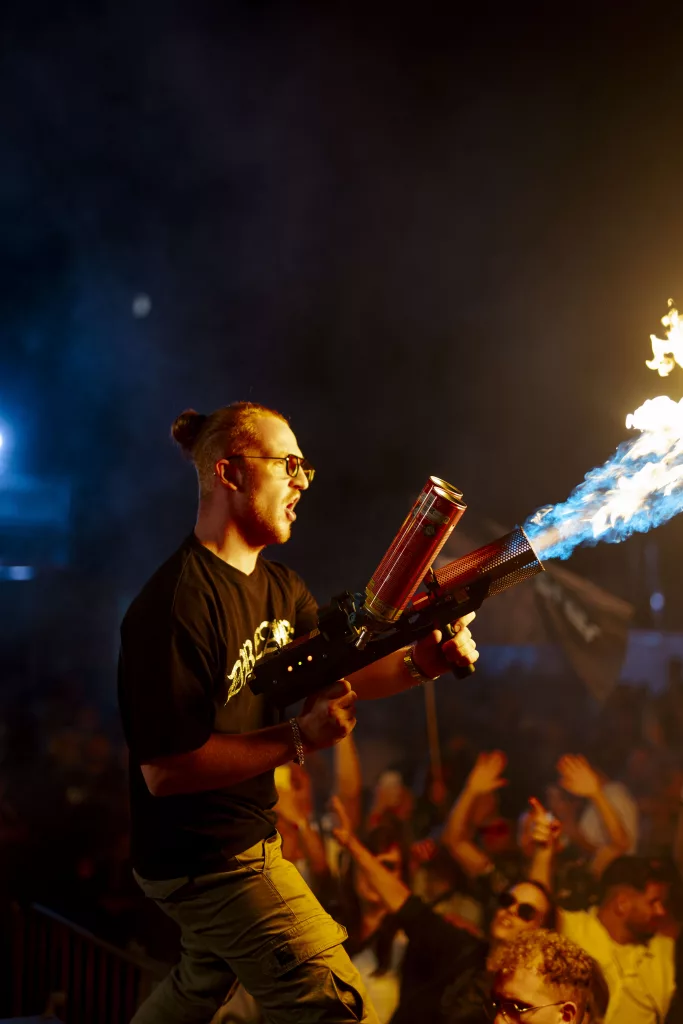 Benster performing live at Klutensee Festival with DJ equipment and vibrant lighting.